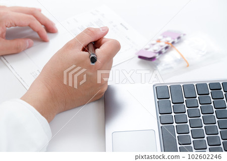 藥劑師檢查處方的手。藥品和醫療費,收據電腦圖像 藥劑師檢查處方的手。藥品和醫療費,收據電腦圖像 102602246