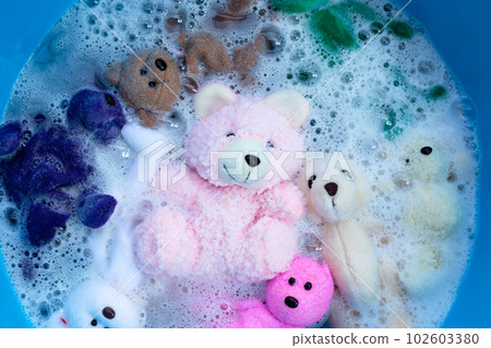 Soak toy teddy bears in laundry detergent water dissolution before washing. Laundry concept, Top view Soak toy teddy bears in laundry detergent water dissolution before washing. Laundry concept, Top view 102603380