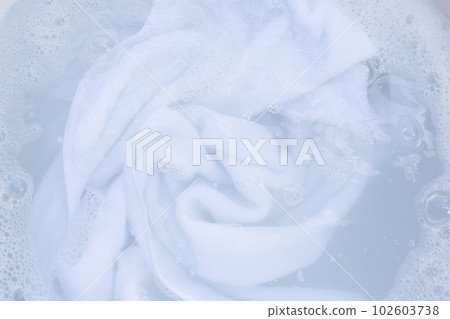 Top view of towel soak in powder detergent water dissolution. Laundry concept Top view of towel soak in powder detergent water dissolution. Laundry concept 102603738