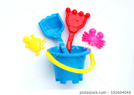 Plastic toys, shovels in bucket for sand on white background. Summer background concept 102604048