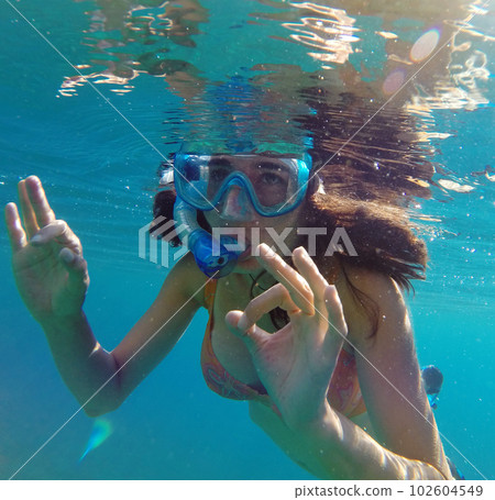 Underwater view of a woman snorkeling in the tropical sea 102604549