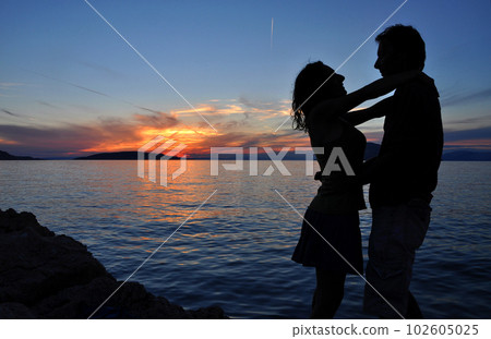 Sea sunset with silhouette of a romantic couple Sea sunset with silhouette of a romantic couple 102605025