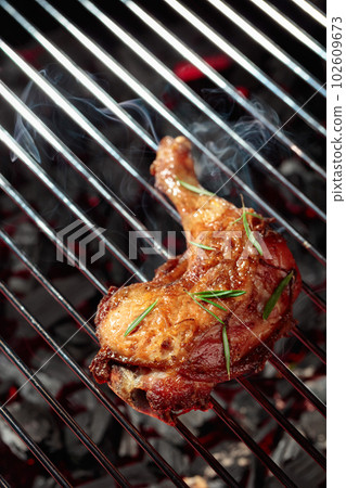 Chicken with rosemary on a grill. 102609673