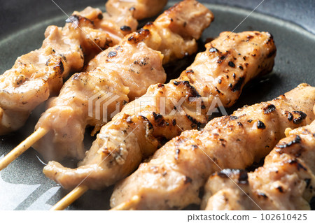 Reheat the yakitori (chicken thigh skewers) in a frying pan (with cooking sake). 102610425