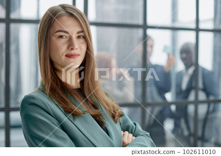 Portrait of a confident young businesswoman standing with her arms crossed in an office Portrait of a confident young businesswoman standing with her arms crossed in an office 102611010