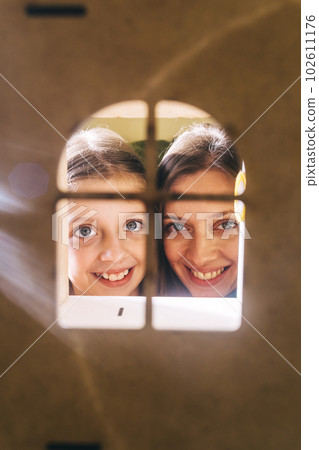 Mom and daughter happy. View from the toy window to the mother and daughter hugging and looking happy. Concept of loving parents and happy childhood. Mom and daughter happy. View from the toy window to the mother and daughter hugging and looking happy. Concept of loving parents and happy childhood. 102611176