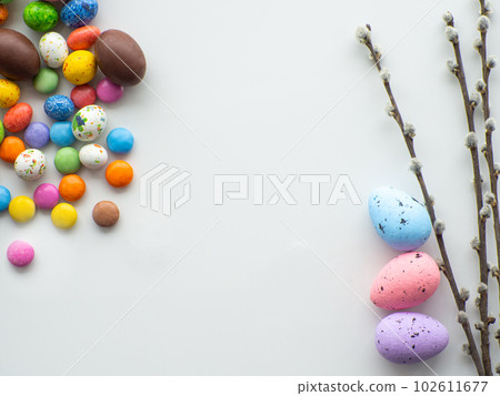 Colorful and chocolate easter eggs with sweet dragee on white background 102611677