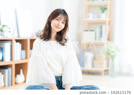 Young woman sitting and relaxing in living room 102613170