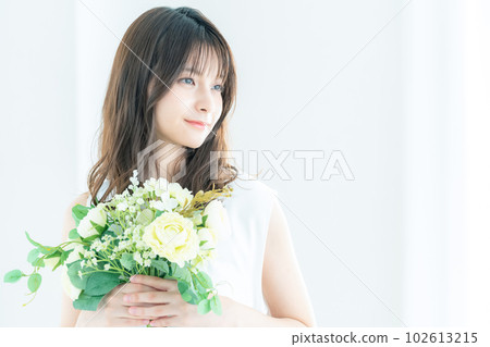 年輕的新娘在窗邊捧著一束花 102613215