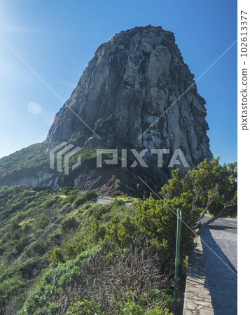 Scenic view on massive volcanic rock formation Roque de Agando in Garajonay National Park on La Gomera, Canary Islands, Spain, Europe. Lava cone of an old volcano, symbol of the island. Vertical 102613377