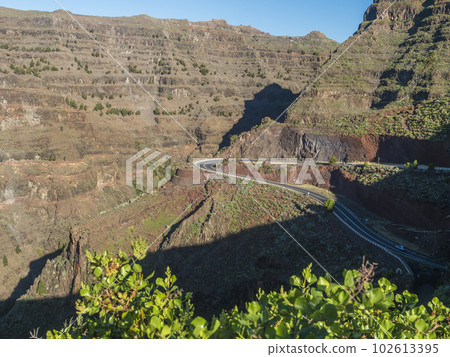 Aerial view from Mirador de la curva del queso. Green valley of Valle Gran Rey with mountain cliffs, ocean and colorful houses village with terraced fields. La Gomera, Canary island, Spain Aerial view from Mirador de la curva del queso. Green valley of Valle Gran Rey with mountain cliffs, ocean and colorful houses village with terraced fields. La Gomera, Canary island, Spain 102613395