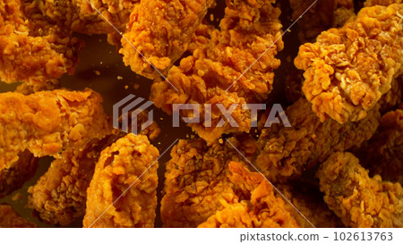 Freeze Motion Shot of Flying Fresh Fried Chicken Wings or Strips, Close-up 102613763