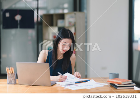 A businesswoman or accountant is using a calculator to work on financial investments, analyzing business and marketing growth on a financial document data graph. A businesswoman or accountant is using a calculator to work on financial investments, analyzing business and marketing growth on a financial document data graph. 102619331