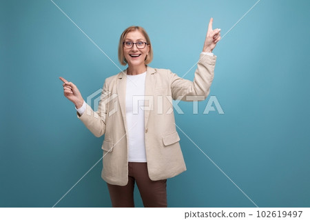 confident adult woman with a bob hairstyle in a classic jacket points her finger to the side on a confident adult woman with a bob hairstyle in a classic jacket points her finger to the side on a 102619497