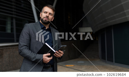 portrait of a european businessman with a notepad in his hands on the background of the building 102619684