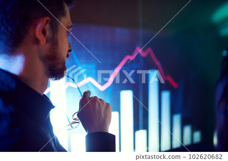 Close-up of male face attentively looking on screen showing presentation, graphs and analytics. CEO businessman in meeting 102620682