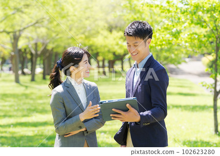 A picture of a business person smiling in the fresh green 102623280