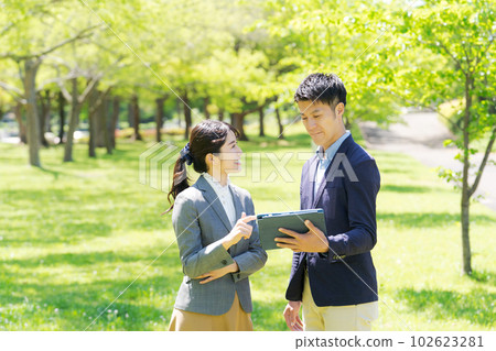 A picture of a business person smiling in the fresh green 102623281