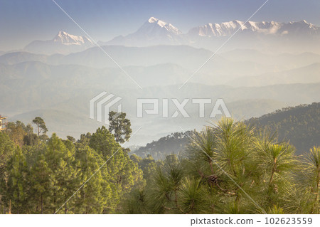 Beautiful Himalayan landscape in morning haze with trees on foreground.. Snow-capped peaks and green Himalayas mountains. Himalayas nature. India landscape. 102623559