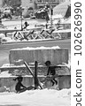 A boy and a girl swing on an anti-tank hedgehog - Banksy graffiti in Kyiv, Ukraine, black and white photo 102626990
