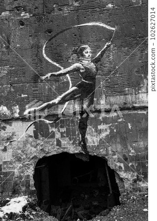 IRPIN, UKRAINE - NOVEMBER 29, 2022: Ukraine, Irpin - Banksy graffiti on the wall of a house, black and white photo 102627014