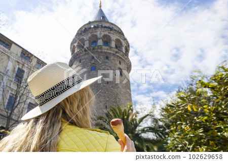Beautiful young tourist girl in fashionable clothes poses with view of landmark Galata tower in Beyoglu,Istanbul,Turkey.Traveler Concept image Beautiful young tourist girl in fashionable clothes poses with view of landmark Galata tower in Beyoglu,Istanbul,Turkey.Traveler Concept image 102629658