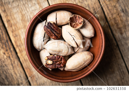 Dried organic Pecan nuts in orange ceramic bowl Dried organic Pecan nuts in orange ceramic bowl 102631338