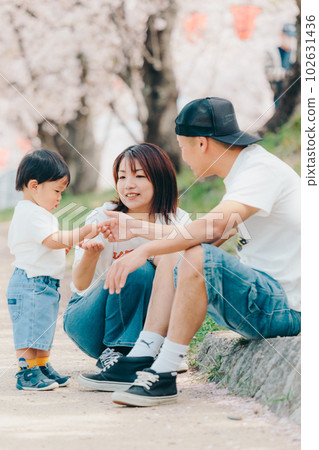 Photo of a family of three standing under a cherry tree Photo of a family of three standing under a cherry tree 102631436