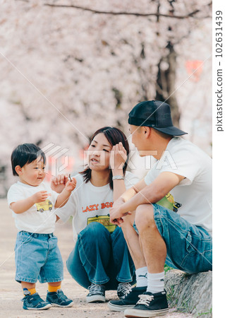 Photo of a family of three standing under a cherry tree 102631439