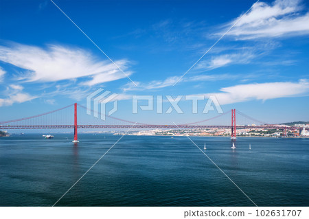 View of 25 de Abril Bridge famous tourist landmark of Lisbon connecting Lisboa to Almada on Setubal Peninsula over Tagus river with boats yachts and vessels. Lisbon, Portugal 102631707