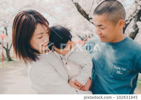 Photo of a family of three standing under a cherry tree Photo of a family of three standing under a cherry tree 102631845