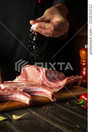 Raw ribs must be salted. The cook adds salt to the meat. Cooking delicious food for the hotel Raw ribs must be salted. The cook adds salt to the meat. Cooking delicious food for the hotel 102632012