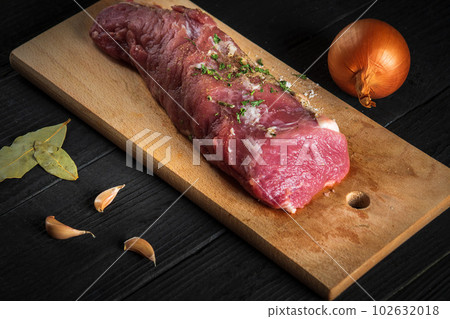 Raw beef meat with vegetables ingredients over cutting board. Preparation before preparing food in restaurant or cafe Raw beef meat with vegetables ingredients over cutting board. Preparation before preparing food in restaurant or cafe 102632018