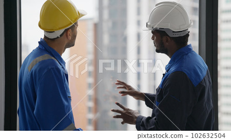 Contractor with safety helmet brainstorming with electrician technician 102632504