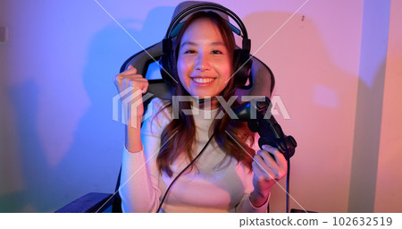 Young woman wearing headphones playing computer game Young woman wearing headphones playing computer game 102632519