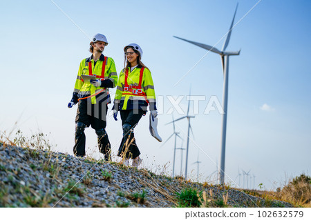Technicians team with safety uniform working at wind turbine field Technicians team with safety uniform working at wind turbine field 102632579
