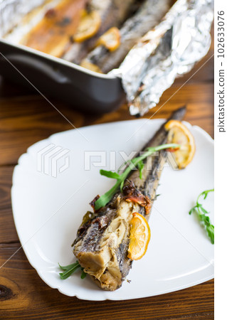 Baked fish with seasonings and spices in a plate 102633076
