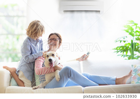 Mother and child with air conditioner remote Mother and child with air conditioner remote 102633930