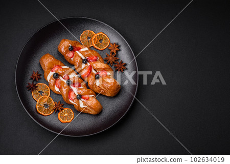 Delicious fresh crispy pastry in the form of a pigtail with strawberries and blueberries Delicious fresh crispy pastry in the form of a pigtail with strawberries and blueberries 102634019