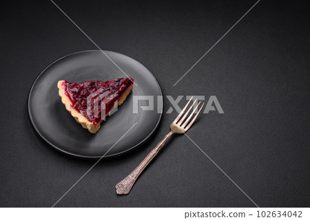 Delicious fragrant sweet pie with cherry berries on a ceramic plate 102634042