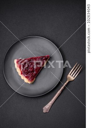 Delicious fragrant sweet pie with cherry berries on a ceramic plate 102634043
