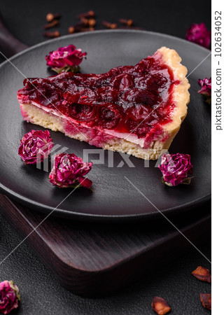 Delicious fragrant sweet pie with cherry berries on a ceramic plate 102634052
