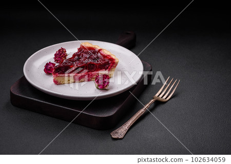 Delicious fragrant sweet pie with cherry berries on a ceramic plate 102634059