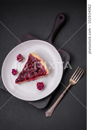Delicious fragrant sweet pie with cherry berries on a ceramic plate 102634062