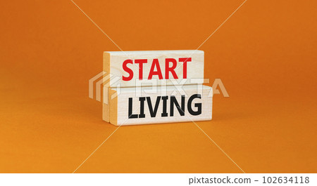 Start living symbol. Concept words Start living on beautiful wooden block. Beautiful orange table orange background. Business and Start living concept. Copy space. Start living symbol. Concept words Start living on beautiful wooden block. Beautiful orange table orange background. Business and Start living concept. Copy space. 102634118