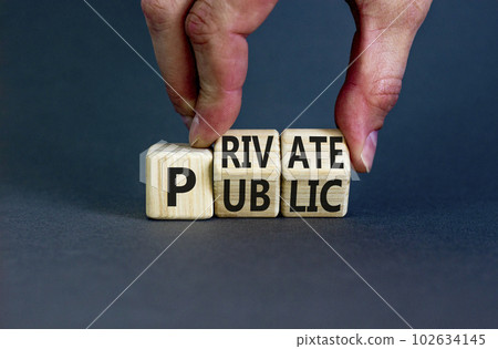 Private or public symbol. Concept words Private or Public on wooden cubes. Businessman hand. Beautiful grey table grey background. Business and private or public concept. Copy space. 102634145