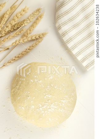 Bread baking concept, dough with wheat ears and towel on white background Bread baking concept, dough with wheat ears and towel on white background 102634238