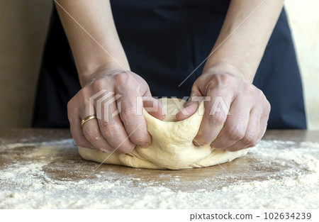 Making dough, close-up of female hands kneading dough for baking bread, Making dough, close-up of female hands kneading dough for baking bread, 102634239