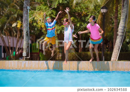 Kids jump into swimming pool. Summer water fun. Kids jump into swimming pool. Summer water fun. 102634588