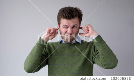 The European young man covers his ears. He doesn't want to hear the uncomfortable truth 102636858
